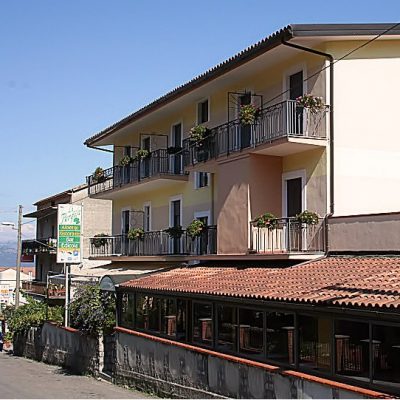 Ein buntes Gebäude mit Balkon, die mit Blumen geschmückt sind - Übernachtung während der individuellen Wanderung in Süd-Italien