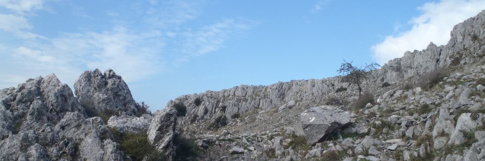 Eine graue Felswand vor hellblauem Himmel - gesehen auf einer individuellen Wanderung in Süd-Italien