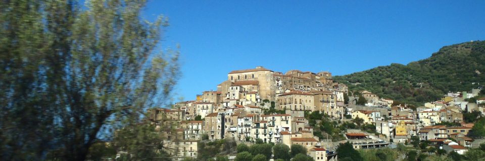 Zahlreiche Häuser innerhalb eines Bergdorfes unter strahlend blauem Himmel - gesehen auf einer individuellen Wanderung in Süd-Italien