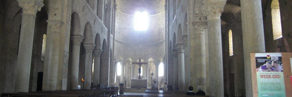 Der Blick durch eine Kirche auf den Altar mit Kreuz - gesehen auf einer individuellen Wanderung in der Toskana